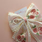 Sheer lace hair bow with cream and pink embroidered flowers