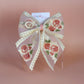 Sheer lace hair bow with cream and pink embroidered flowers
