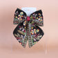 Black hair bow with colourful burgundy and gold embroidered floral pattern