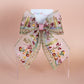 Transparent hair bow with colourful burgundy and gold embroidered floral pattern