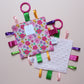 Sensory crinkle tag toy with pink floral pattern
