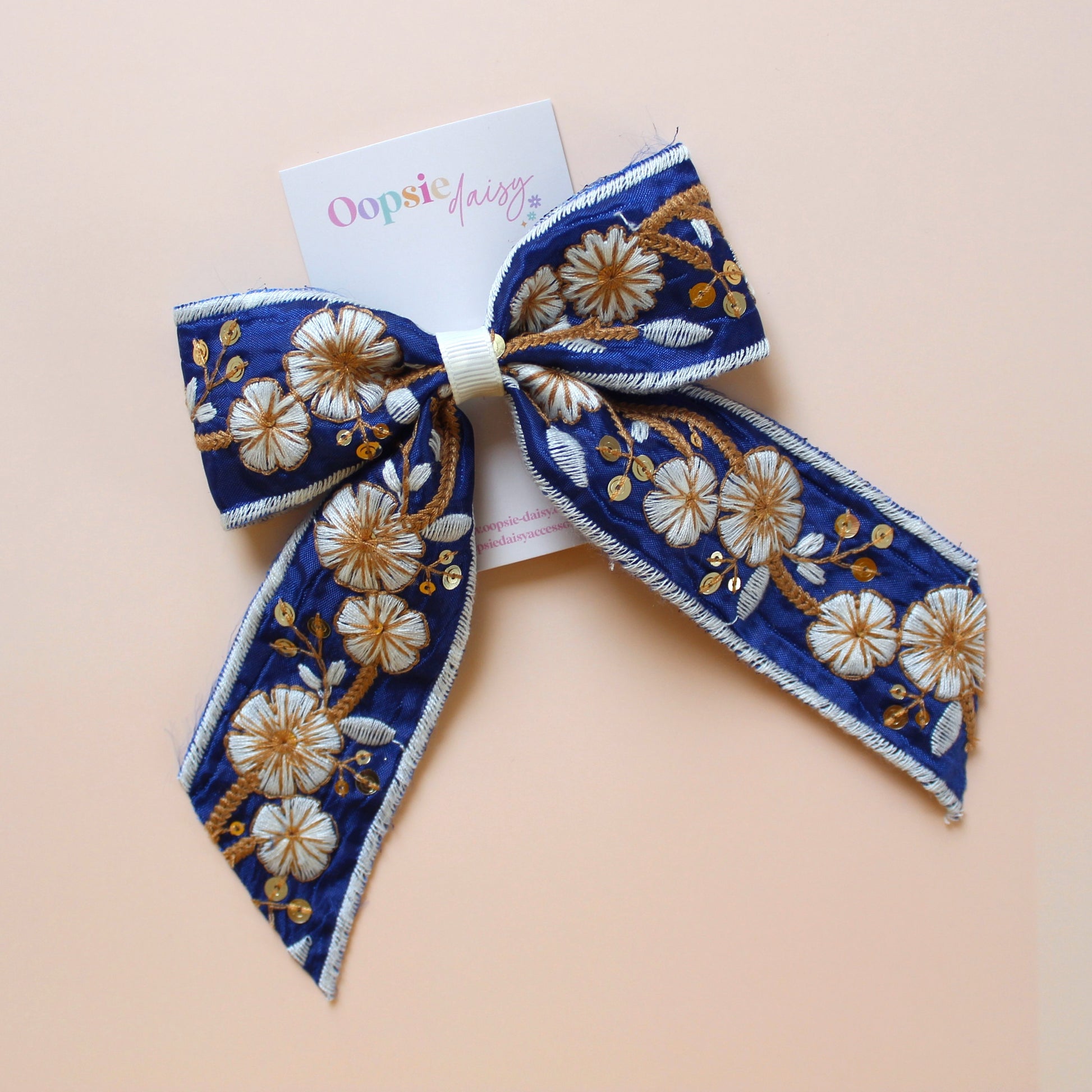 Blue and white embroidered hair bow with floral pattern