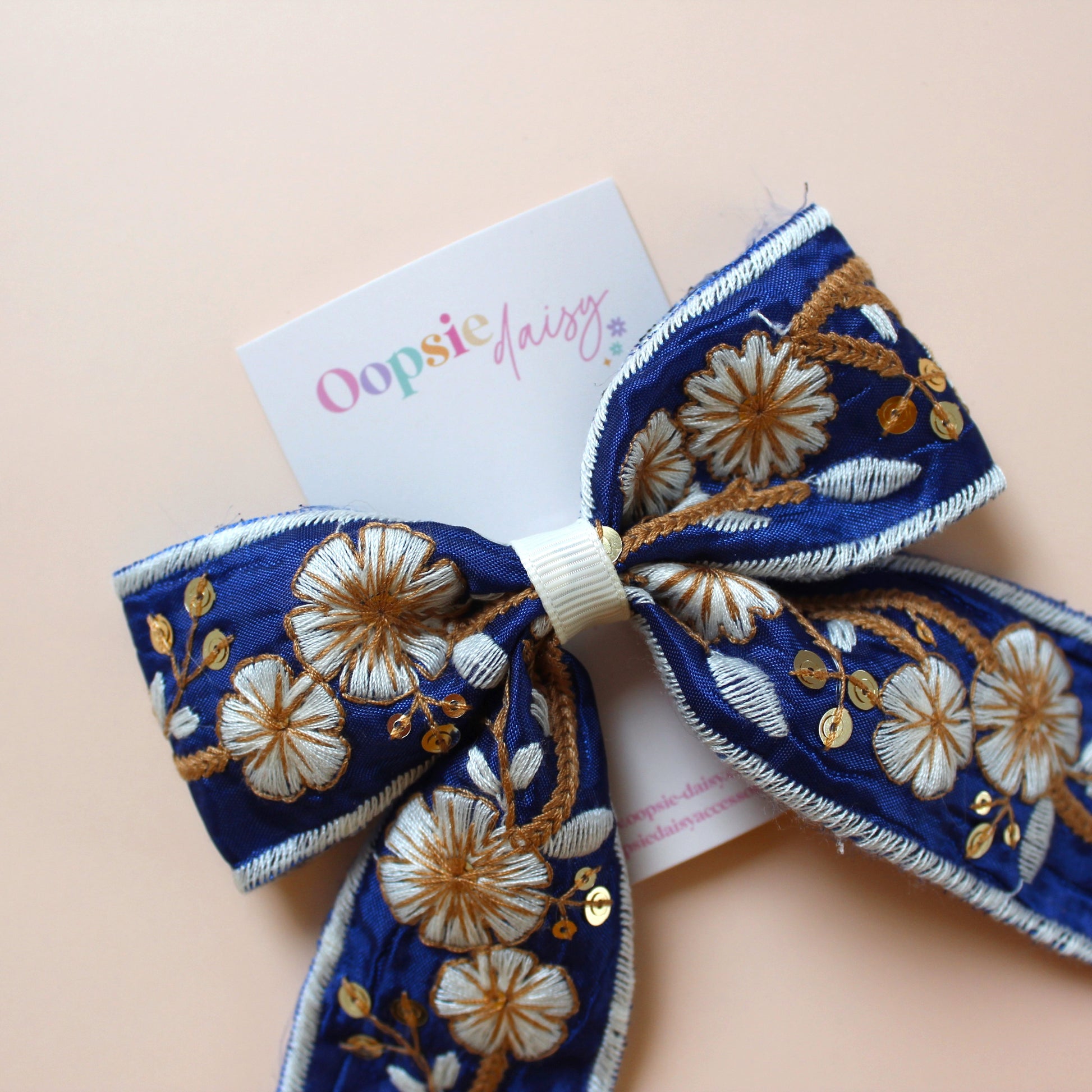 Blue and white embroidered hair bow with floral pattern