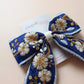 Blue and white embroidered hair bow with floral pattern