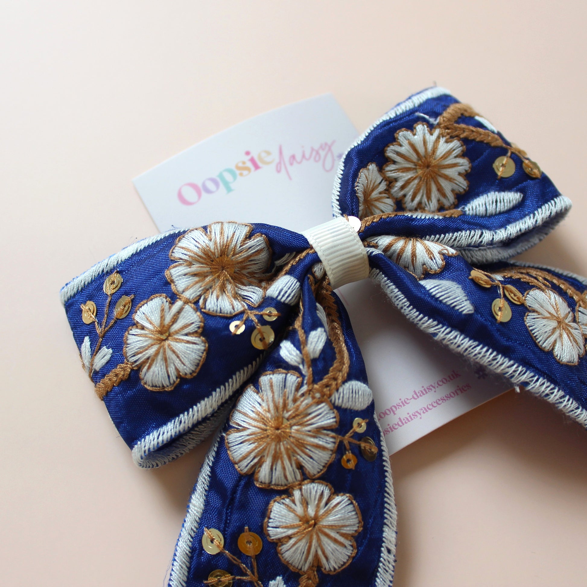 Blue and white embroidered hair bow with floral pattern