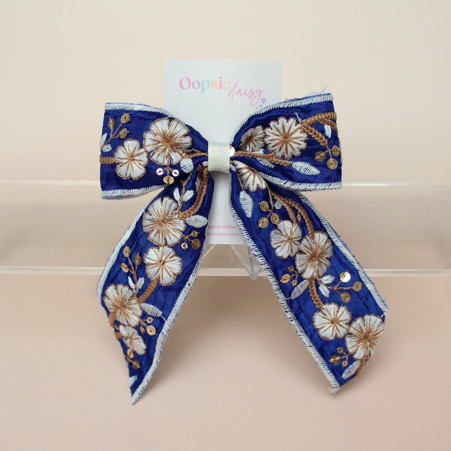 Blue and white embroidered hair bow with floral pattern